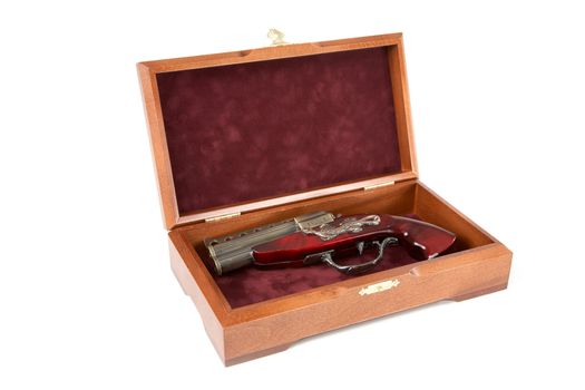 Casket with a toy pistol on a white background