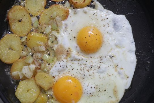 fried eggs and potatoes in the pan