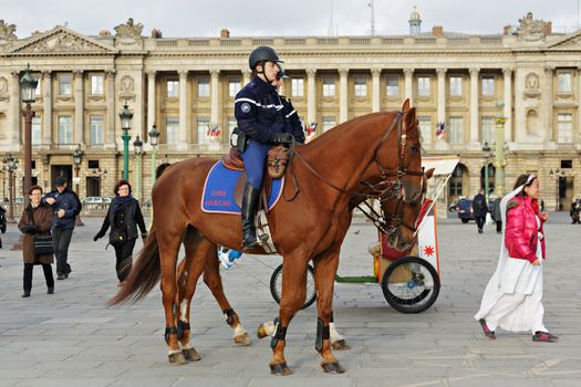 PARIS - NOV 10 : French policeman are patrolling on the champs elysees by horse in Paris, Nov 10, 2012, Paris, France. Two policemen riding on horseback cruise the streets in the area near the Carrousel Garden in Paris.