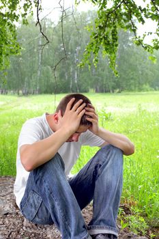 sad teenager sitting in the forest alone