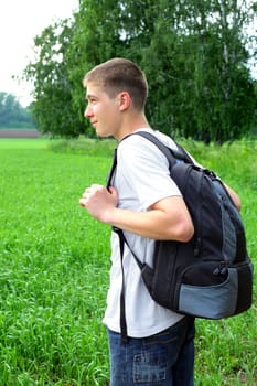 teenager with knapsack in the summer field