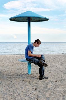 teenager reading letter on the empty beach