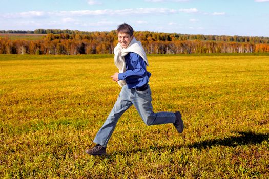 happy teenager running on the autumn field