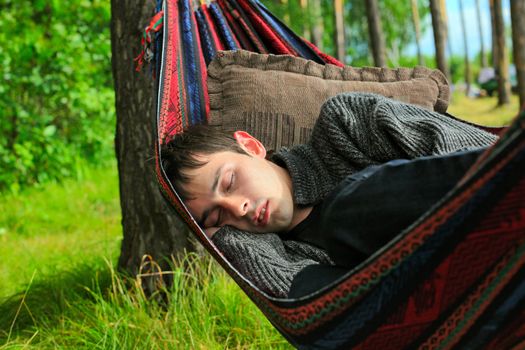 young man sleeping in the hammock on the nature