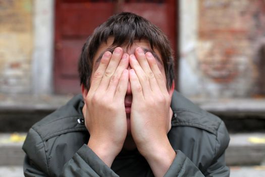 man with hidden face on the old house background