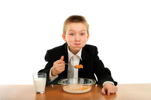 schoolboy eating corn flakes isolated on the white