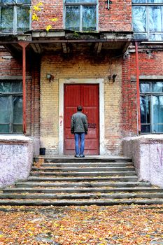 man stand in front of the old house with closed door