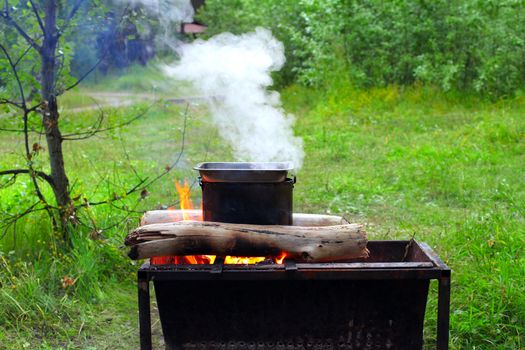 Preparing food on campfire in wild camping