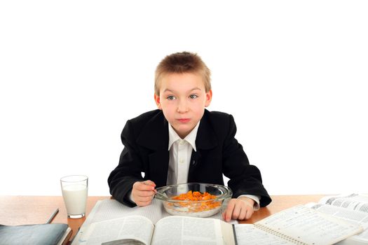 schoolboy eating corn flakes isolated on the white