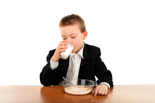 schoolboy eating corn flakes isolated on the white