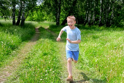 happy boy running in the summer forest