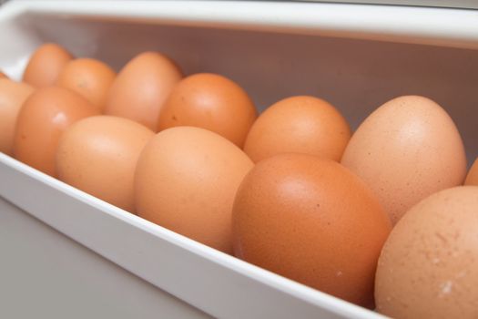 closeup of a pile of brown eggs in the fridge 