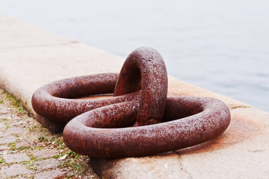 Rusted iron mooring rings on harbor