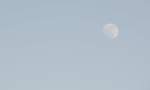 Almost full moon on a blue sky in the afternoon