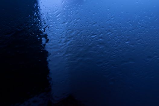 Spray water on a blue background close up