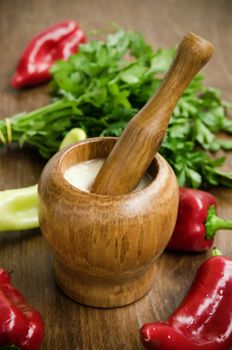 Garlic sauce with vegetables on rustic background