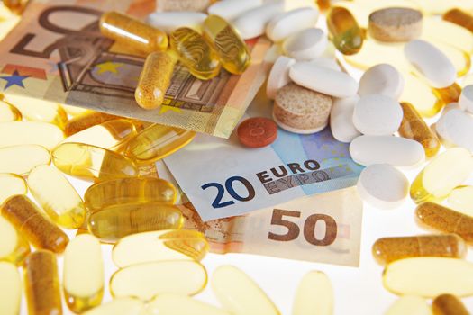 Pills and the euro on a white background