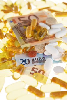 Pills and the euro on a white background