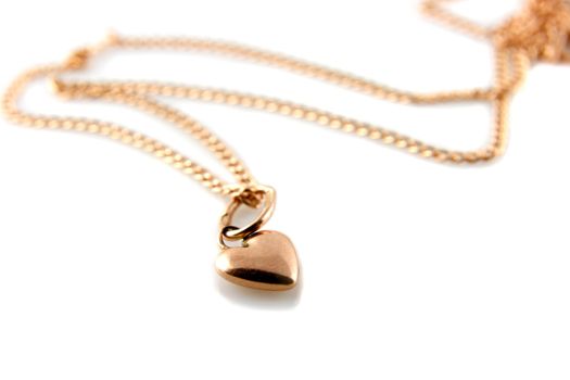 Gold heart pendant with chain on white background