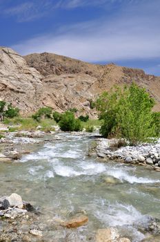 Rushing whitewater flows through a desert canyon near the town of Palm Springs, California.