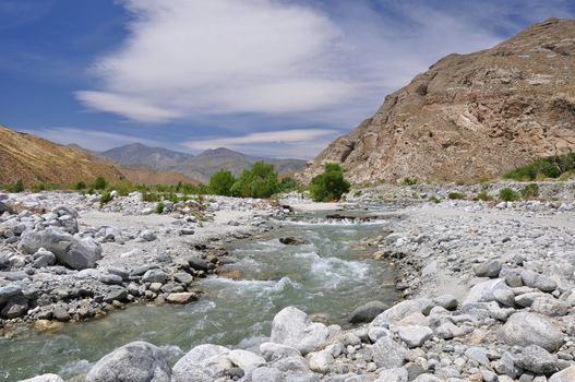 Rushing water flows through an arid desert canyon near the town of Palm Springs, California.