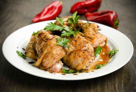 Grilled chicken breast with pepper sauce against wooden background