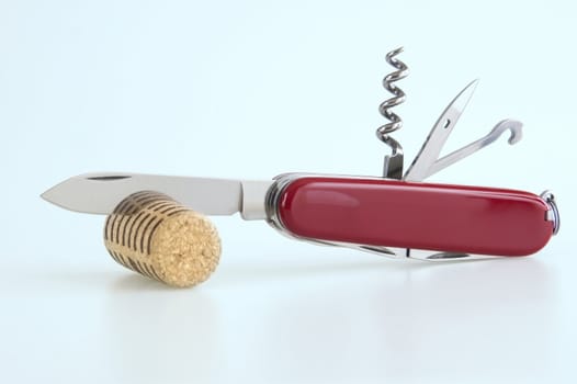 A swiss army knife cutting a cork