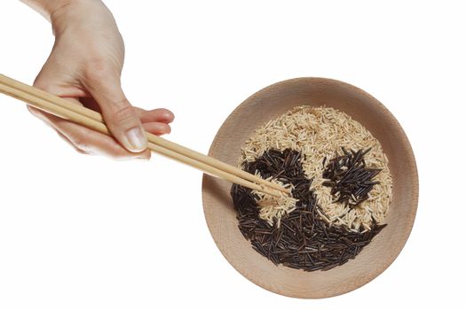 Bowl of rice in Yin and Yang symbol. And hand with chopstics adding last grain of rice.