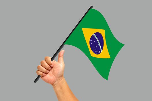 Hand holding brazil flag isolated on white background