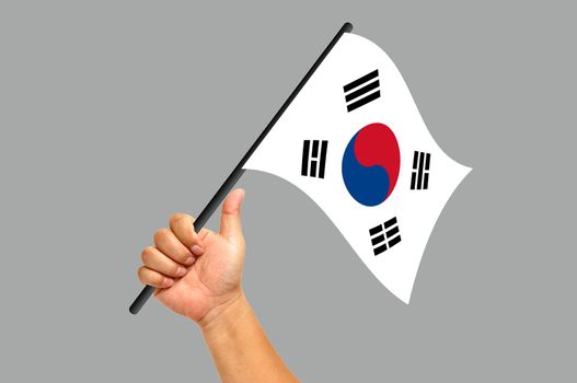 Hand holding South Korea flag isolated on white background