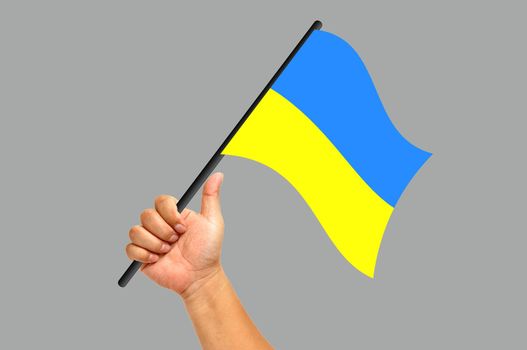 Hand holding ukraine flag isolated on white background