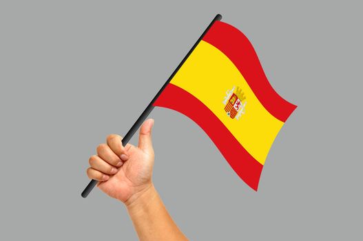 Hand holding spain flag isolated on white background