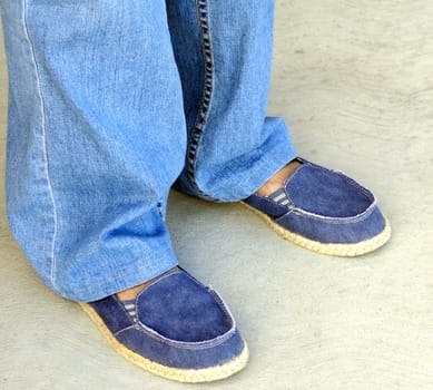 Female wearing denim pants and shoes.