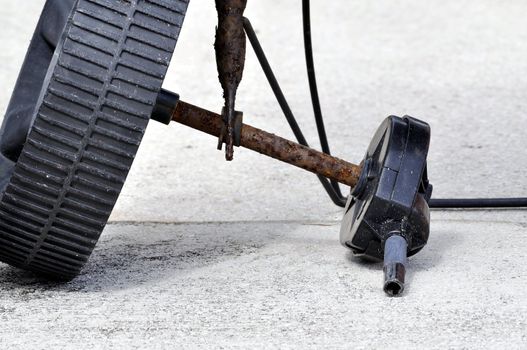 Closeup of broken and rusted fertilizer spreader.