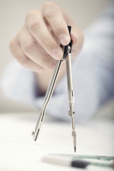 Hand of engineer working with compasses