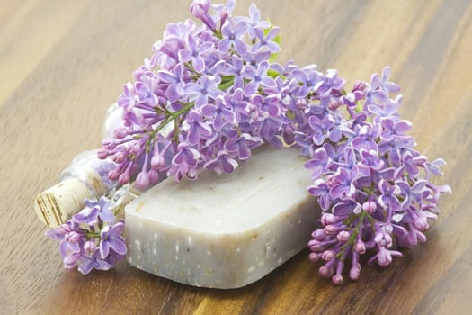 bar of natural soap, bath salt and lilac flowers