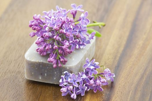 bar of natural soap and lilac flowers