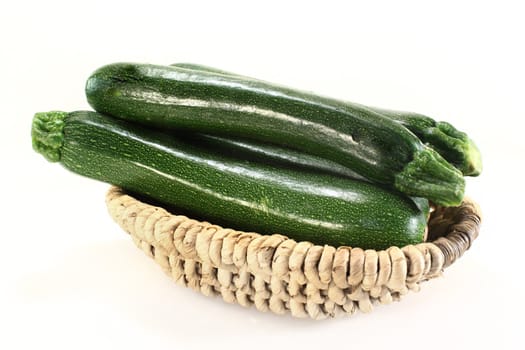 three green zucchini in a basket