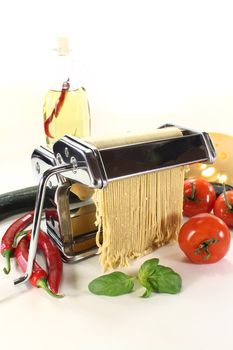 Spaghetti in a pasta machine with tomatoes, garlic and basil
