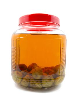 After pickle Japanese plum liqueur in glass jar with rice whiskey and rock sugar isolated