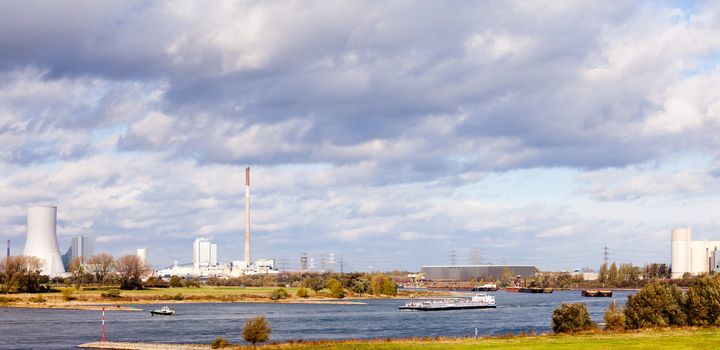Industrial landscape of transportation waterway river Rhine busy with loaded barges near Duisburg North Rhine-Westphalia Germany Europe