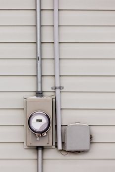Modern smart grid residential digital power supply meter beside telecommunication connection box on exterior wall