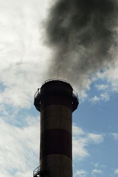 Dark chimney polluting the clear skies