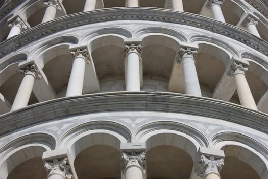 Famous Leaning Tower in Pisa detail of the marble arches on piazza dei Miracoli.