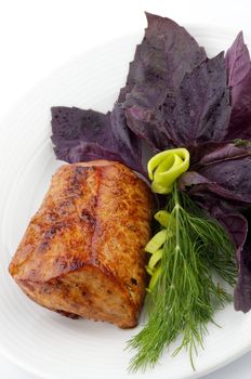 Spicy Roast Pork tenderloin with basil, dill and leek closeup on white background