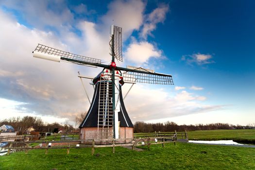 traditional Dutch windmill over blue sky with white clouds during a day