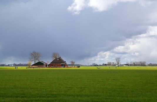 storm cloud over Dutch farm among green pastures