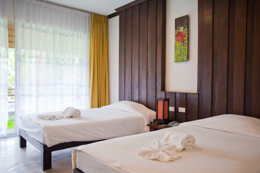 Hotel room in a tropical resort with bed and wooden flooring