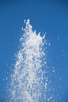 Fountain of pure brilliant water against a blue clear sky