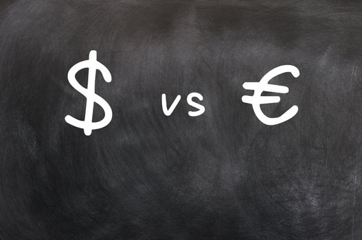 Dollar vs Euro - symbols written with chalk on a blackboard